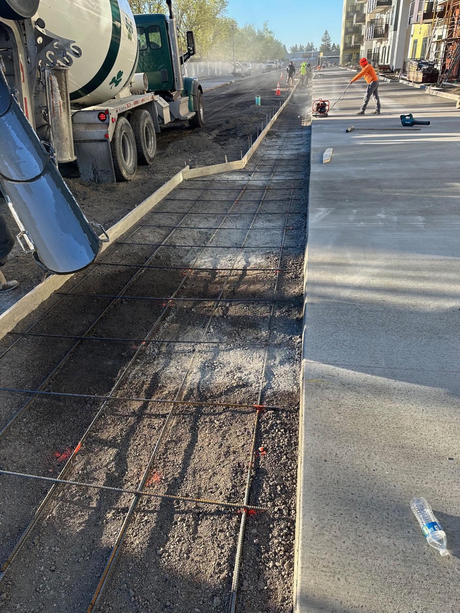 Concrete mixer truck pouring over a rebar mat for new flatwork